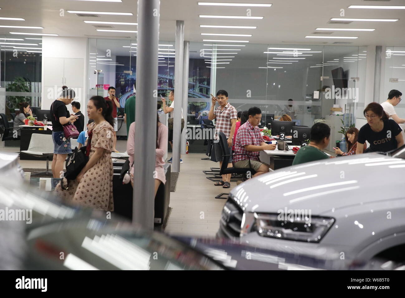 Gli acquirenti cinesi shop per vetture Audi presso un concessionario durante la notte prima di Hainan acquisto auto politica di restrizione prende effetto nel centro della città di Haikou, sud della Cina di Foto Stock