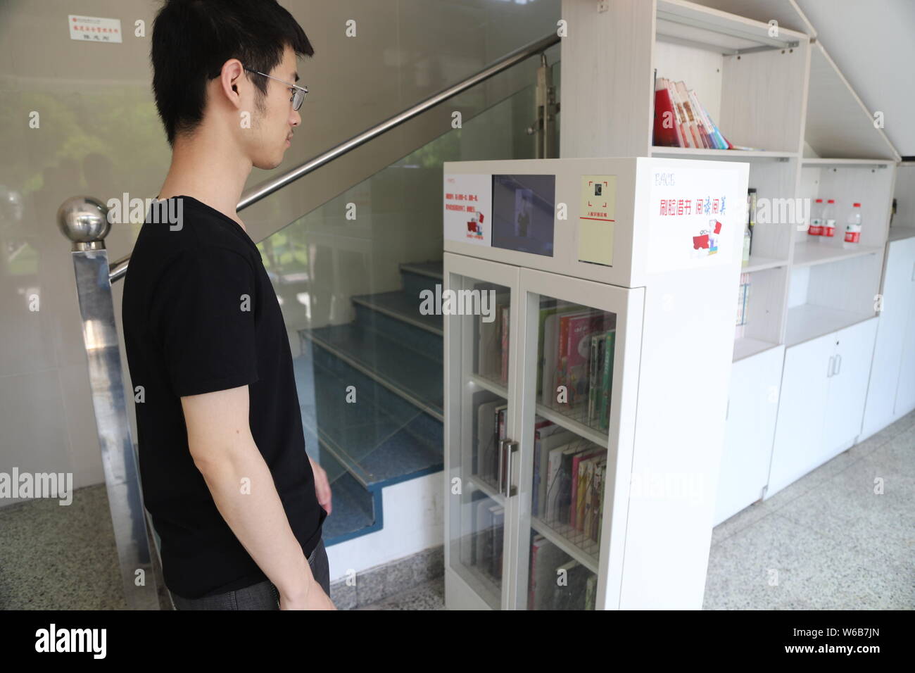 Uno studente prende in prestito libro mediante il riconoscimento del volto nella libreria in una scuola nella città di Hangzhou, a est della Cina di provincia dello Zhejiang, 15 maggio 2018. Il classr Foto Stock