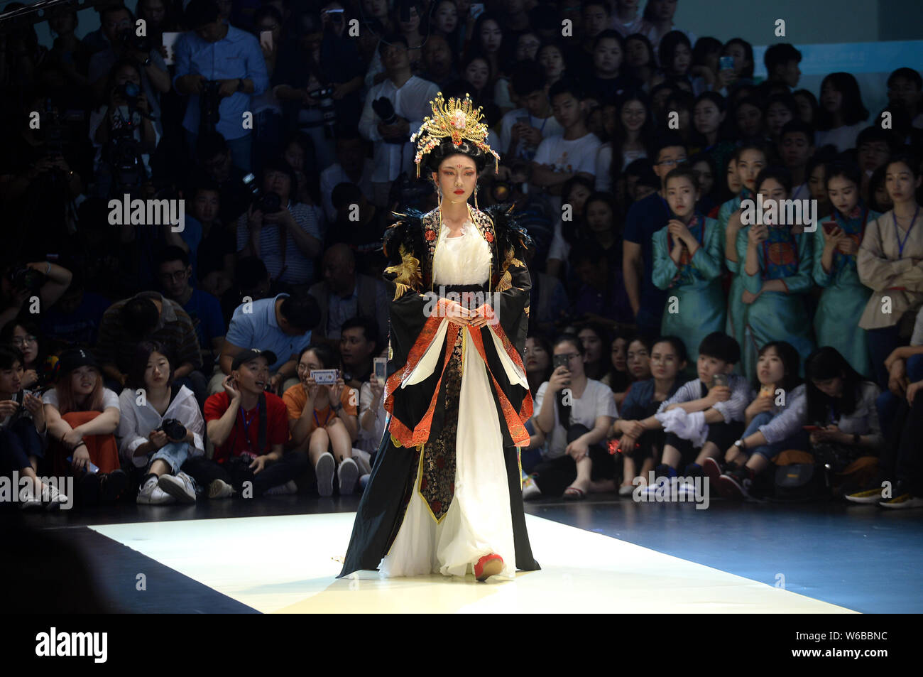 Un modello consente di visualizzare una creazione da un laureato durante una sfilata di moda per la laurea progettazione di opere a tema miti e cinese di romanzi classici presso Shandong Uni Foto Stock