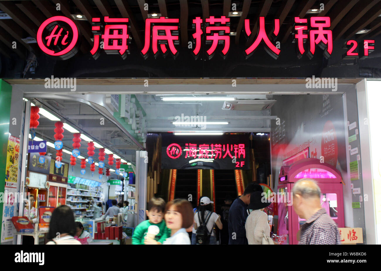 --FILE--pedoni a piedi passato una bollitore ristorante di Hai di Lao nella città di Xiamen, a sud-est della Cina di provincia del Fujian, 21 aprile 2018. Haidilao Ristorante Foto Stock