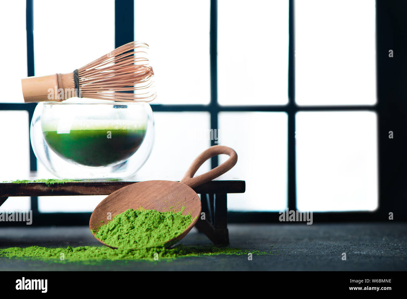 Tè verde Matcha in una doppia parete di vetro tazza di tè con una frusta di bambù. Shoji porte scorrevoli sfondo, tradizionale cerimonia giapponese Foto Stock