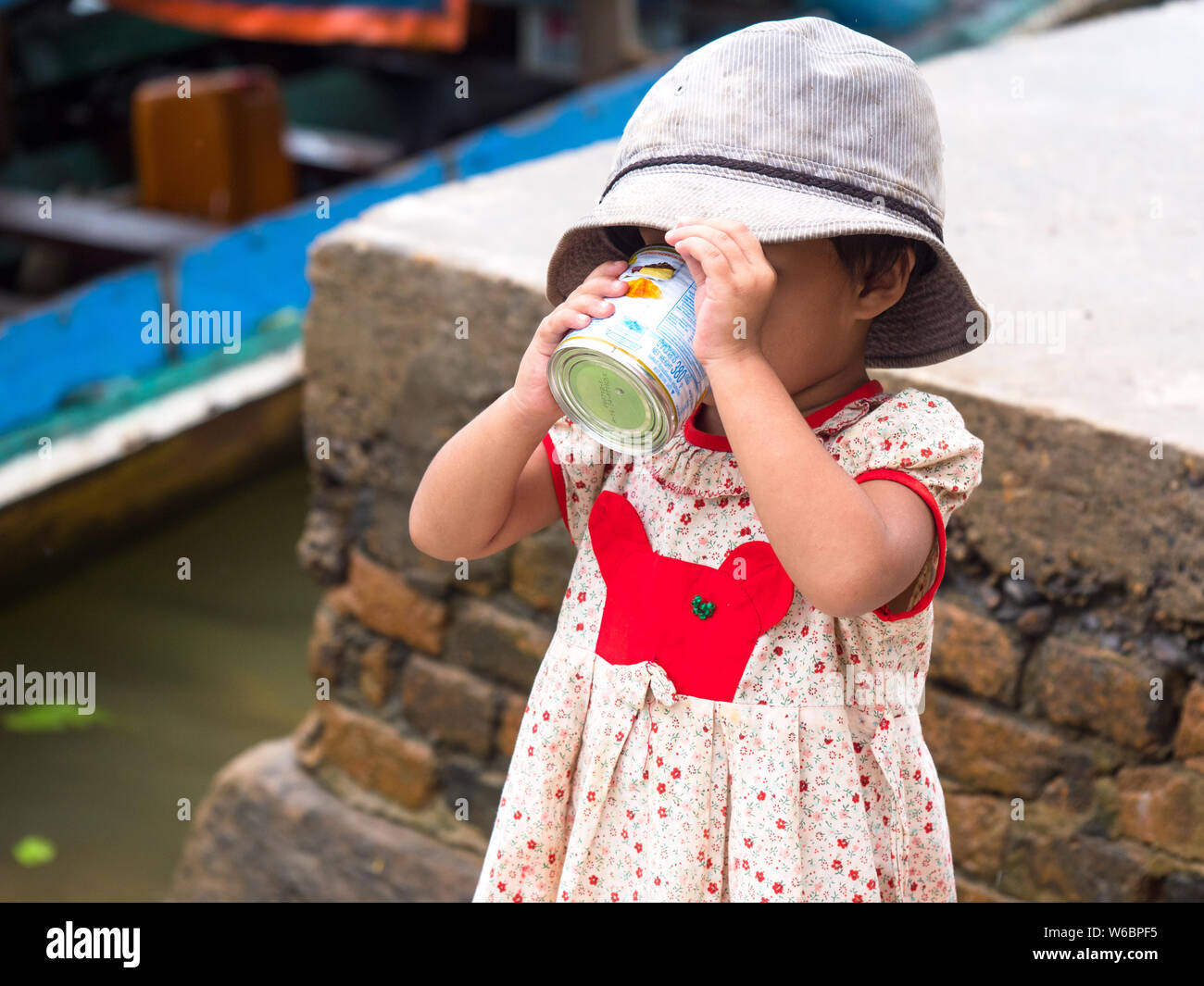 Tagu, Myanmar - 8 Novembre 2017: piccola ragazza di bere il latte condensato zuccherato latte presso la cittadina di Tagu nella regione di Tanintharyi di Myanma meridionale Foto Stock