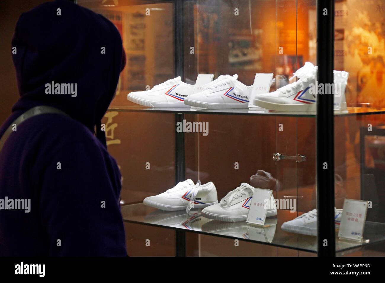 --FILE--un visitatore guarda sneakers cinese di scarpe da ginnastica maker Warrior durante una mostra a Shanghai in Cina, 7 dicembre 2017. Guerriero, il 9 Foto Stock