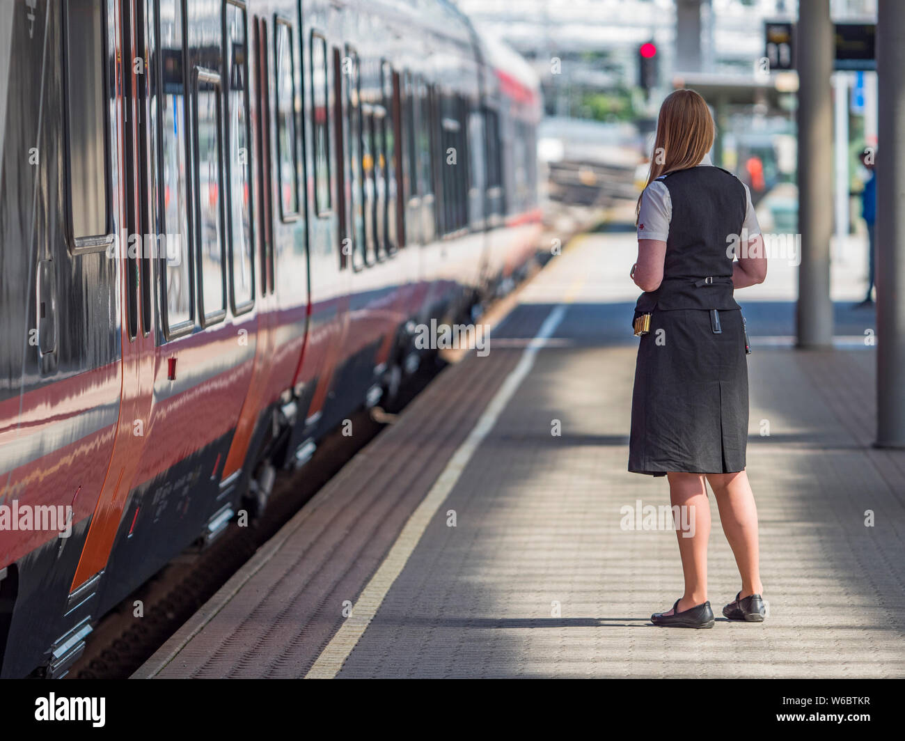 Oslo - Giugno 15, 2017: femmina del personale ferroviario e uno dei popolari Stadler Flirt treni locali a Oslo dalla stazione centrale di Oslo, Norvegia. Questi fast e c Foto Stock