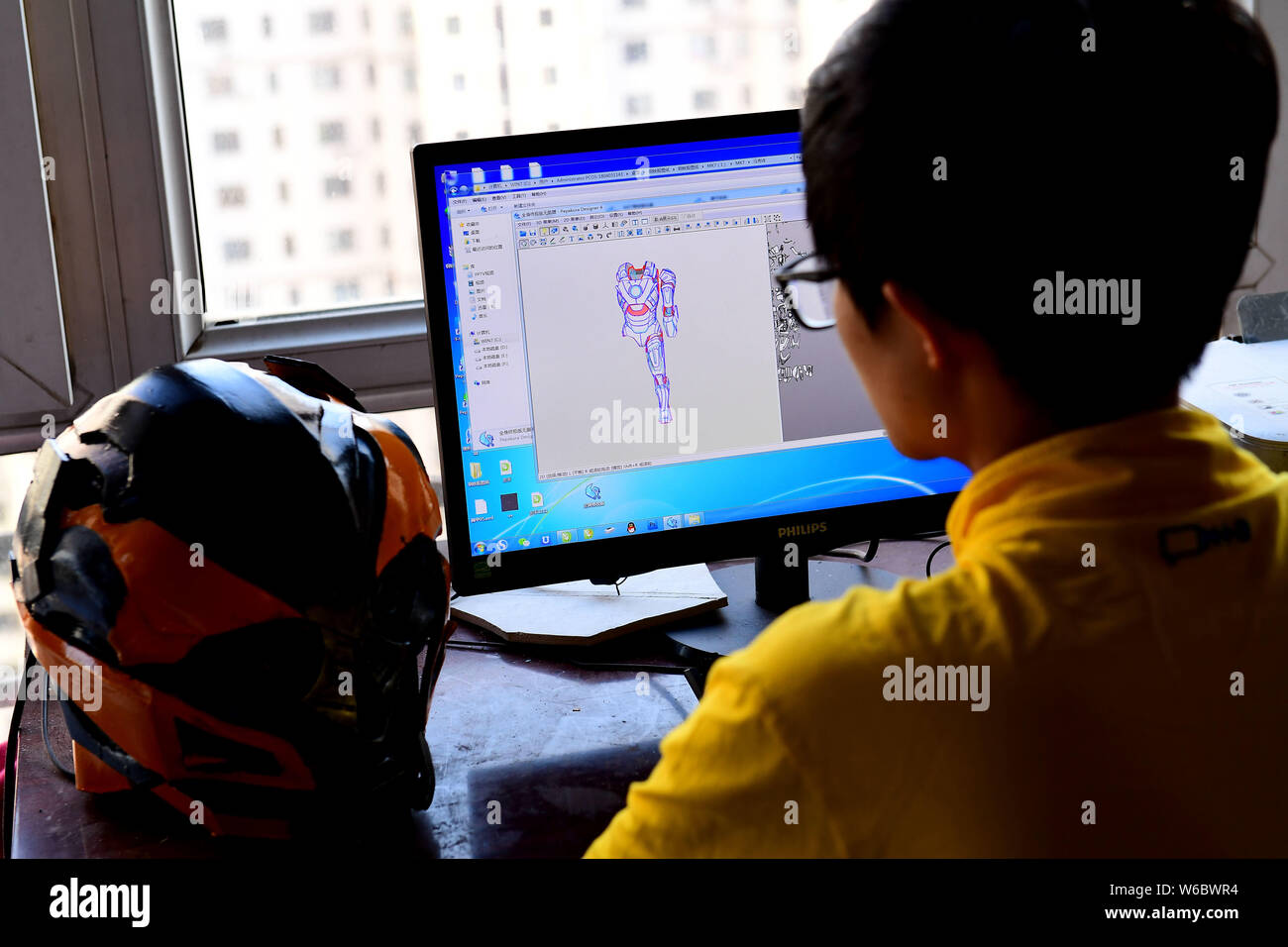--FILE--25-anno-vecchio uomo cinese Liu Sen progetta un costume realistico di un anime carattere sul suo computer presso la sua officina a Shenyang City, a nord-est Foto Stock
