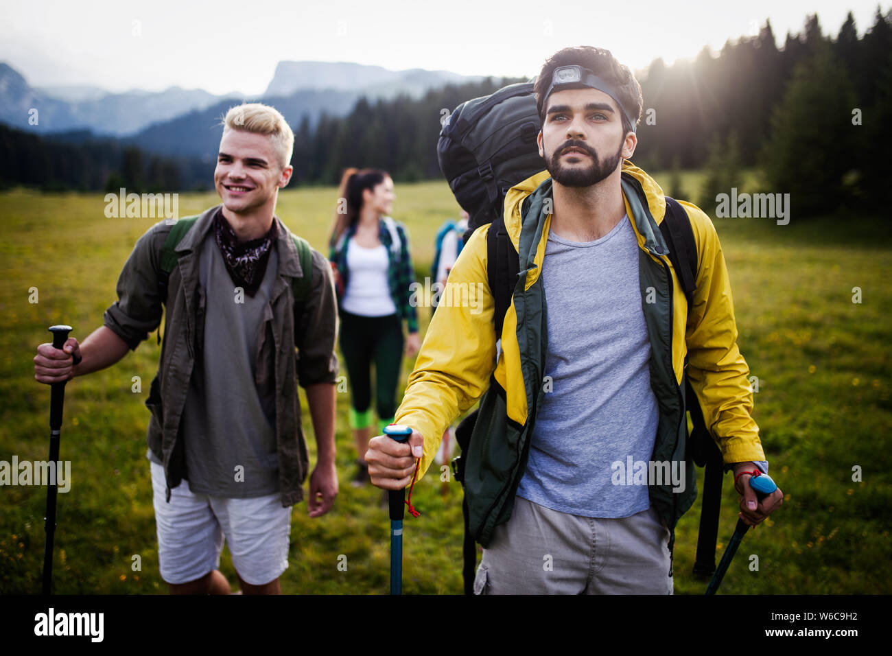 Giovani amici su un paese a piedi. Gruppo di persone passeggiate attraverso la campagna Foto Stock