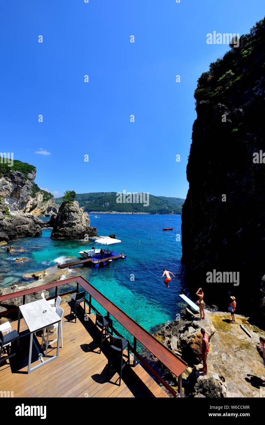 Un uomo tuffarsi nel mare,La Grotta Beach Bar,Paleokastritsa,Corfù, Grecia Foto Stock
