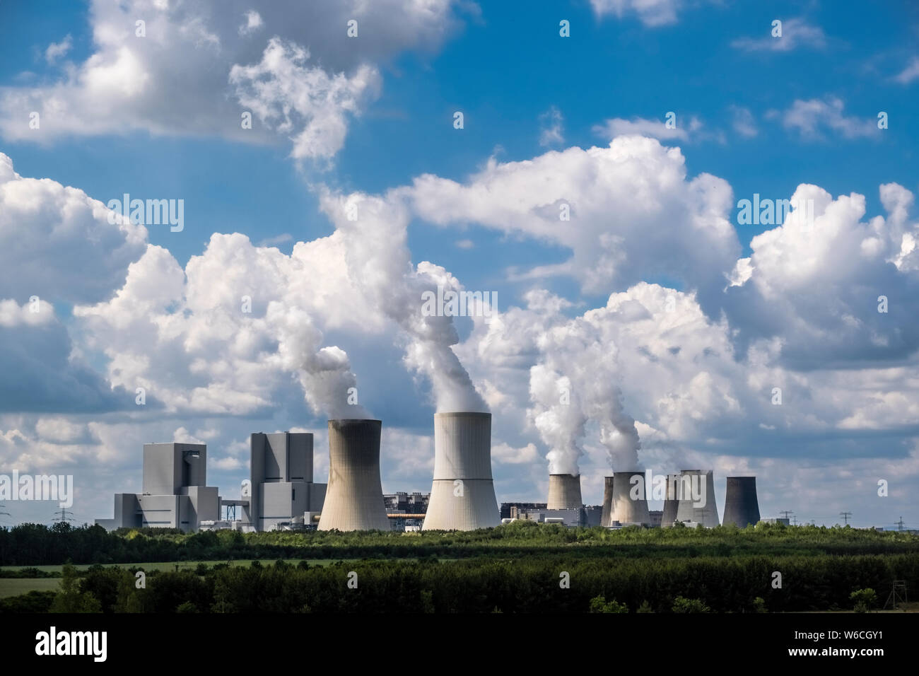 Gli edifici e la cottura a vapore delle torri di raffreddamento di un impianto alimentato a carbone nel paesaggio agricolo Foto Stock