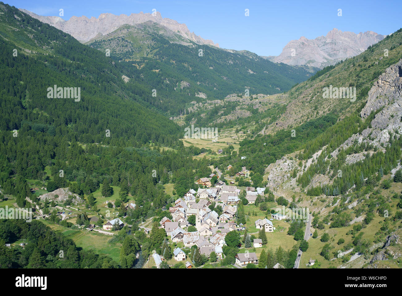 VISTA AEREA. Incontaminata alta valle Clarée con il villaggio di Névache. Côte Alpi, Provenza-Alpi-Costa Azzurra, Francia. Foto Stock
