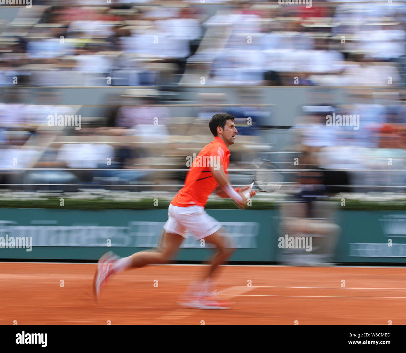 Moto sfocata del tennista serbo Novak Djokovic in esecuzione in avanti durante il French Open 2019, Parigi, Francia Foto Stock