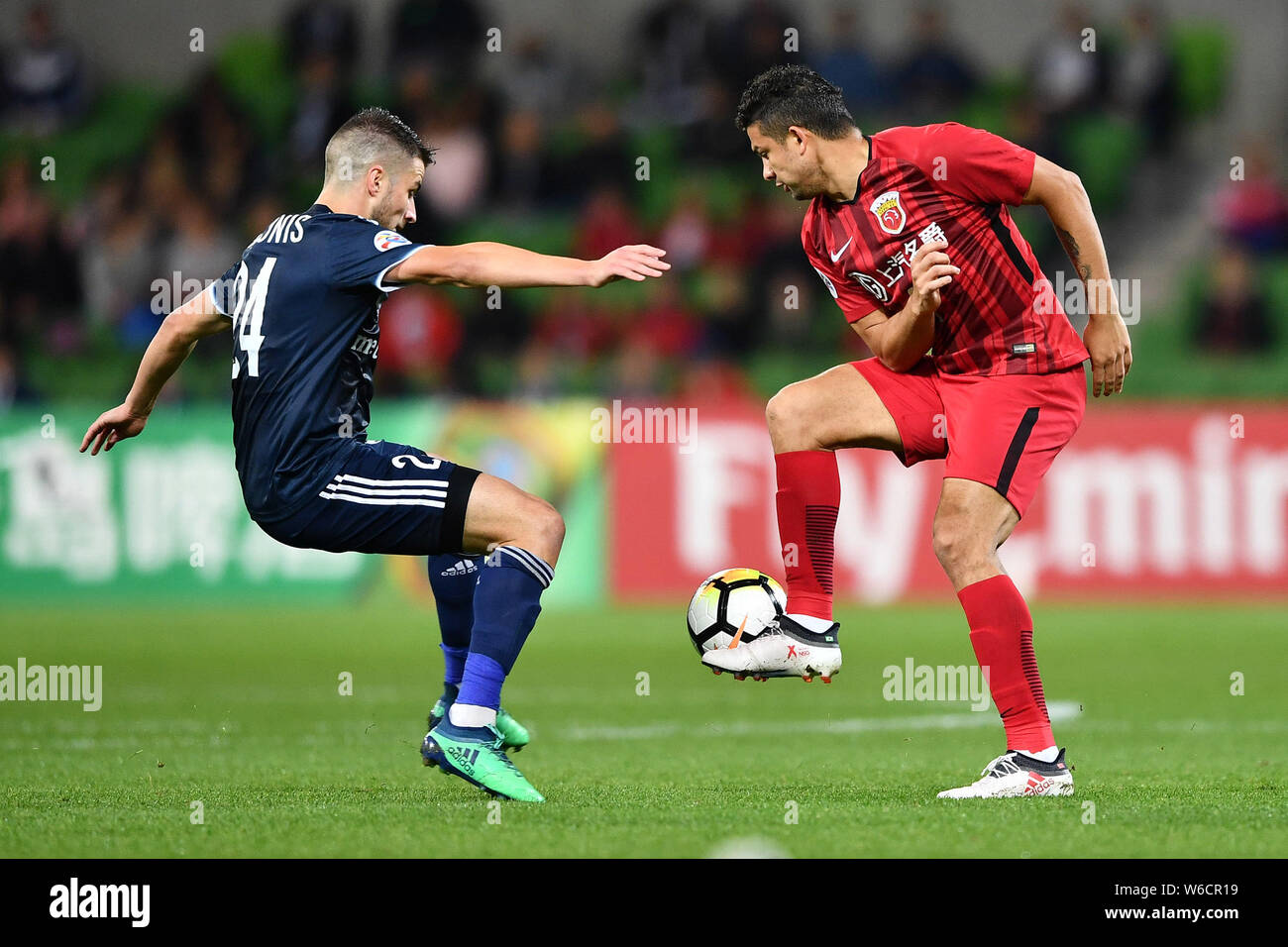 Il calcio brasiliano player Elkeson di cinese di Shanghai SIPG FC, a destra, sfide Terry Antonis dell'Australia Melbourne vittoria FC nel loro gruppo F ma Foto Stock