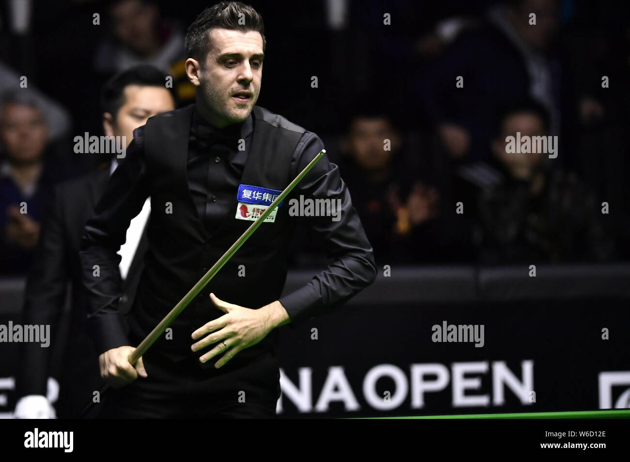 Mark Selby di Inghilterra ritiene che un colpo di Mark Williams del Galles nel loro quarterfinal match durante il 2018 World Snooker China Open a Pechino, mento Foto Stock