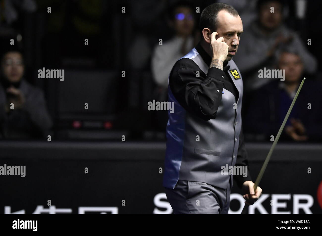 Mark Williams del Galles ritiene che un colpo di Mark Selby di Inghilterra nel loro quarterfinal match durante il 2018 World Snooker China Open a Pechino, mento Foto Stock