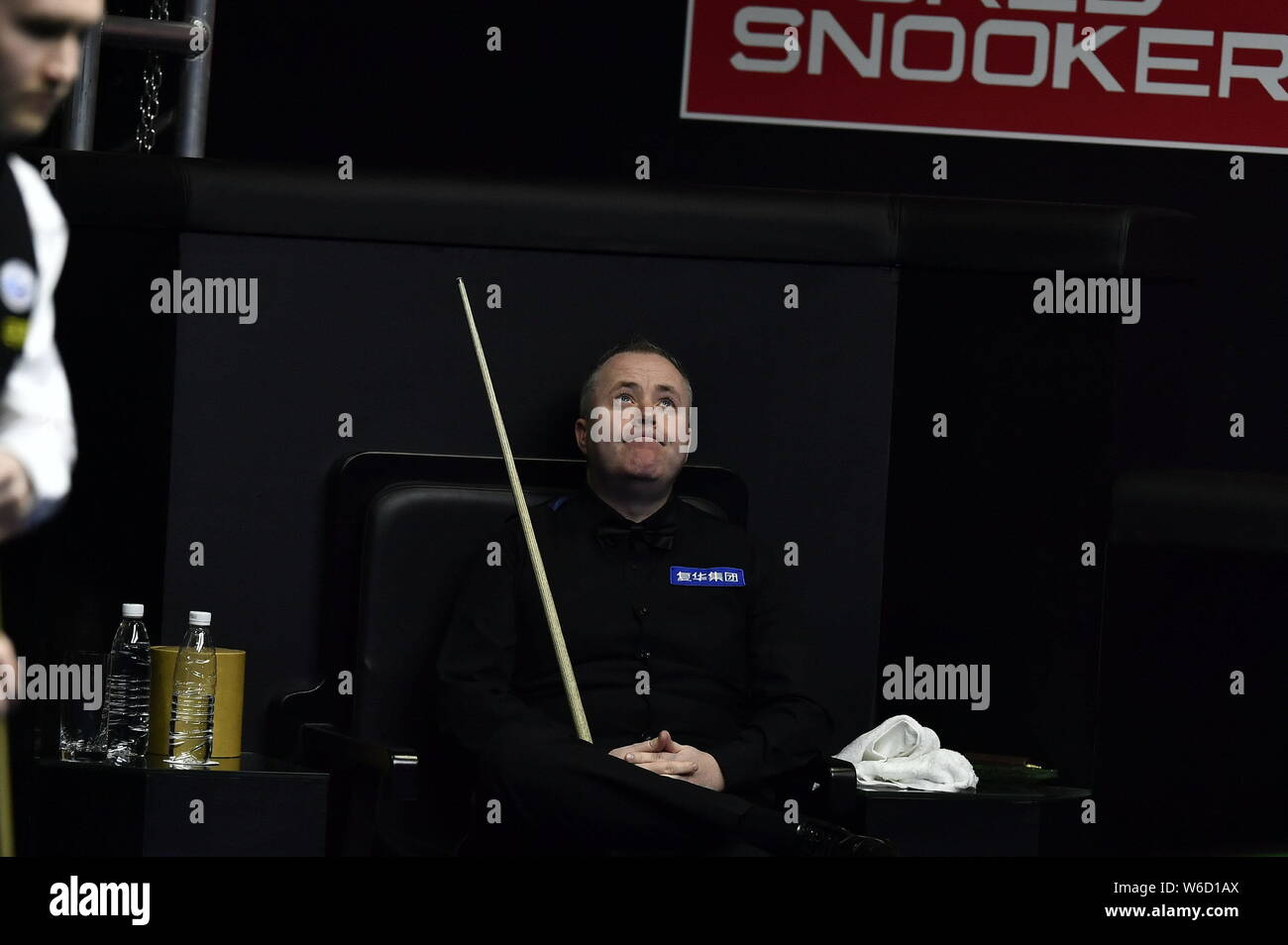 John Higgins della Scozia reagisce come egli orologi Martin O'Donnell di Inghilterra giocando in un colpo il loro match di primo turno durante il 2018 World Snooker mento Foto Stock