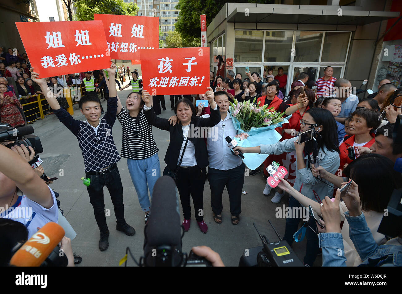 Le famiglie di cinesi ride-driver condivisione Wang Mingqing attendere per la loro famiglia mancanti Kang Ying dopo 24 anni di ricerca nella città di Chengdu, southwest ch Foto Stock