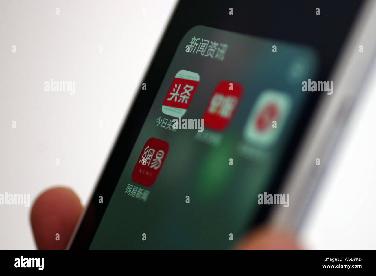 --FILE--un cinese telefono cellulare utente guarda le icone delle applicazioni mobile di (in alto a sinistra) Toutiao, Tiantian Kuaibao, Phoenix notizie e NetEase News Foto Stock