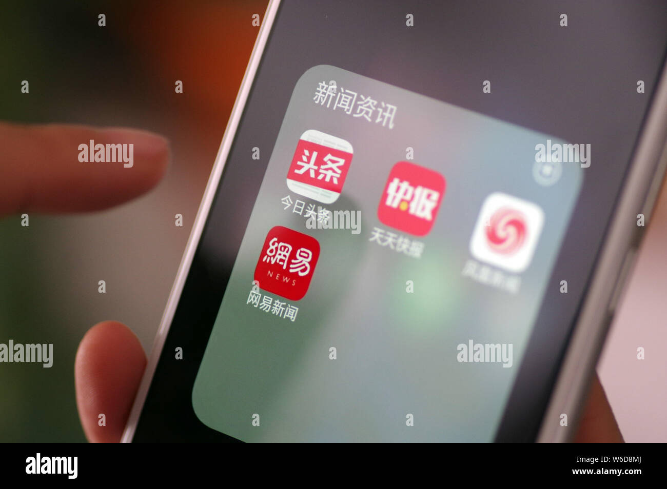 --FILE--un cinese telefono cellulare utente guarda le icone delle applicazioni mobile di (in alto a sinistra) Toutiao, Tiantian Kuaibao, Phoenix notizie e NetEase News Foto Stock
