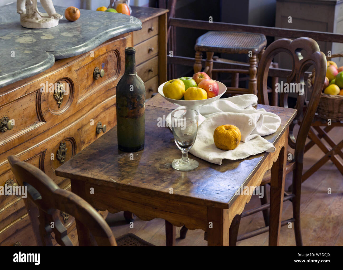 Frutta, bicchiere di vino e una bottiglia la disposizione con la mobilia di periodo in studio del francese Post-Impressionist artista Paul Cezanne in Aix-en-Provence, Prov Foto Stock