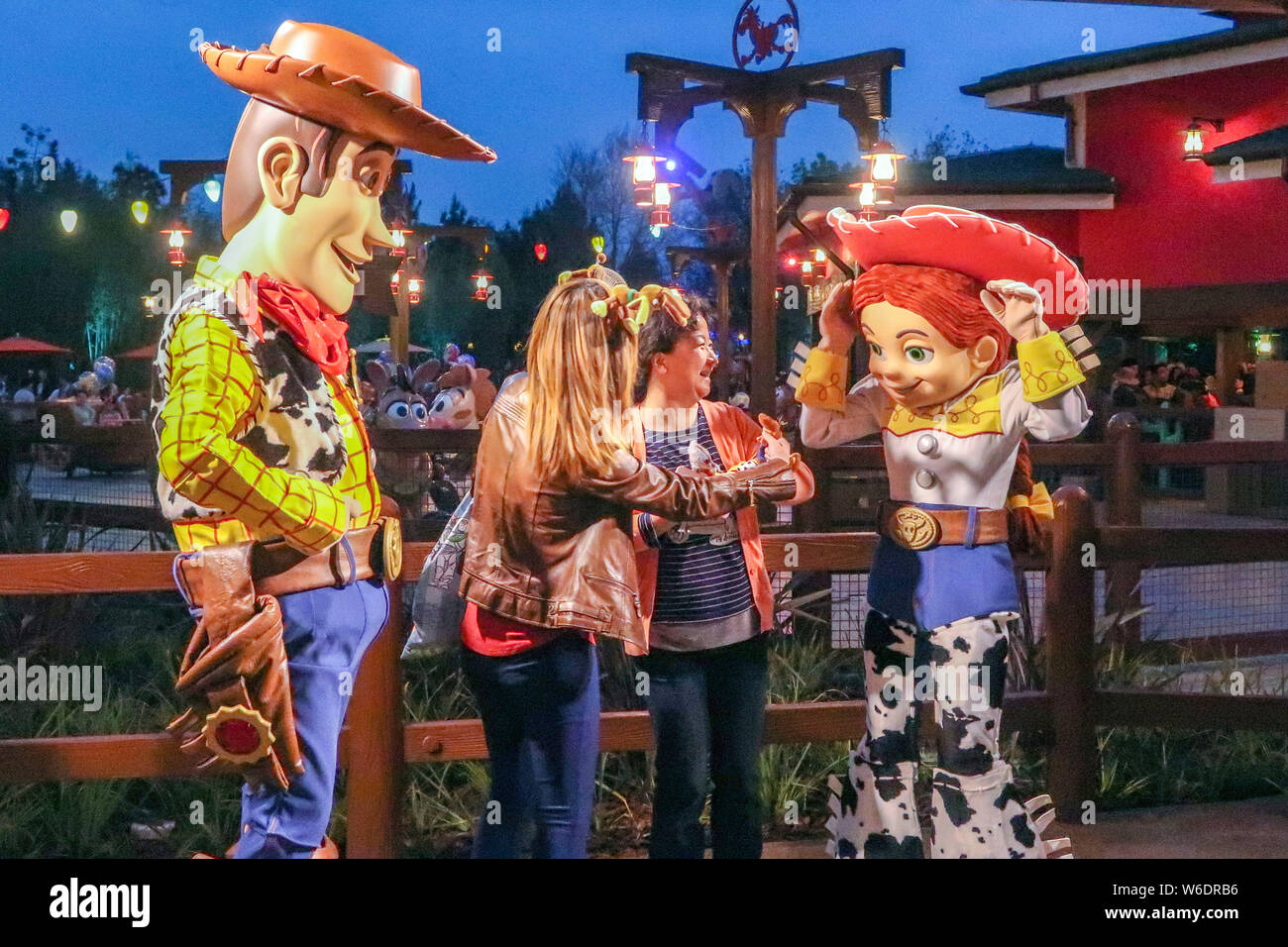 Visitatori posano con sculture di sceriffo Woody e Jessie, entrambi i personaggi della Pixar animate di film "Toy Story", il settimo paese a tema, Disney Pi Foto Stock