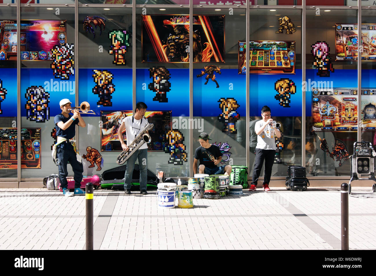 Musicisti di strada giocare davanti a un videogioco shop nella regione di Akihabara Foto Stock