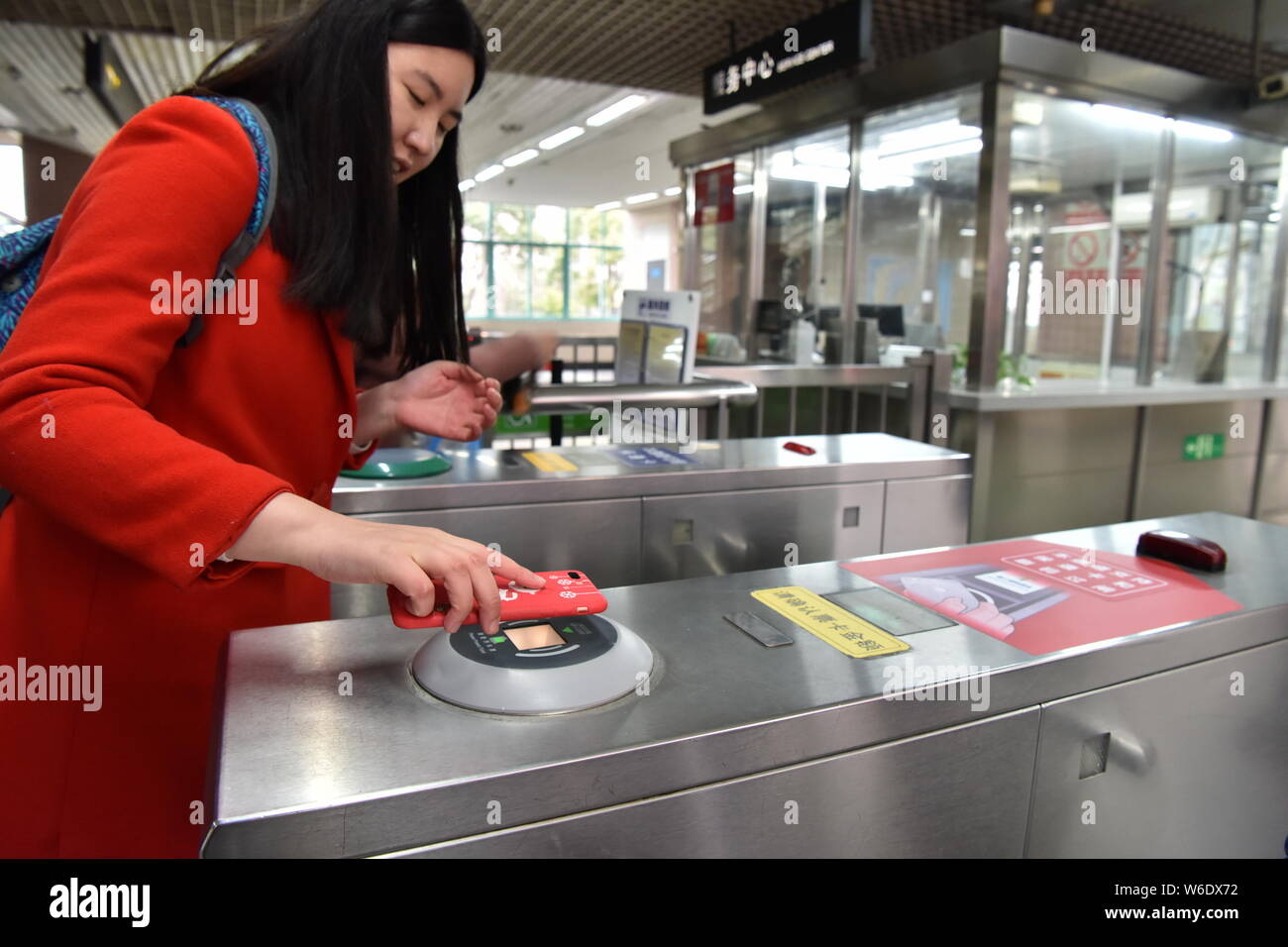 --FILE--un passeggero mette il suo smartphone al di sopra di un tornello per avere il codice QR su un mobile app scansionati a pagare per il biglietto della metropolitana via Alipay o Cina Uni Foto Stock