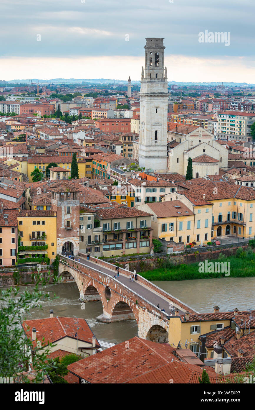 Vista sui tetti di Verona, Italia, attraverso il fiume Adige e il ponte in pietra (Ponte Pietro) con la torre della cattedrale che domina. Foto Stock