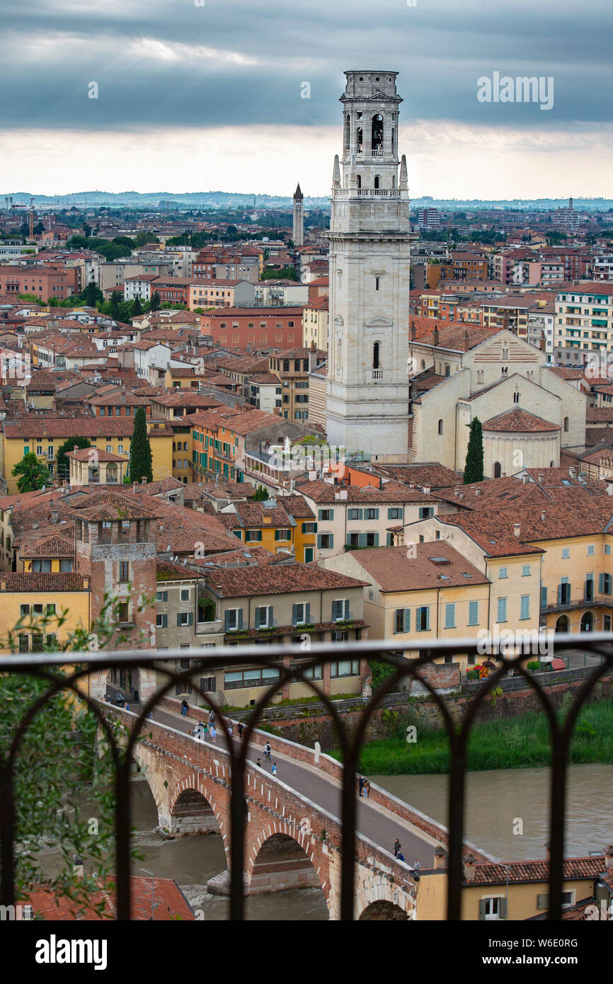 Vista sui tetti di Verona, Italia, attraverso il fiume Adige e il ponte in pietra (Ponte Pietro) con la torre della cattedrale che domina. Foto Stock