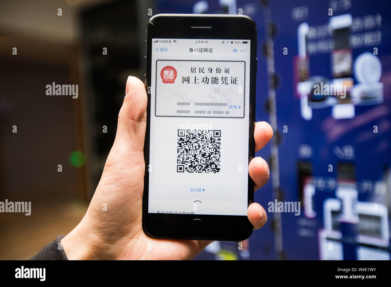 Un uomo cinese senza il suo ID card su di lui utilizza la carta di identità elettronica' nel pagamento mobile app Alipay sul suo smartphone per verificare se stesso come egli chec Foto Stock