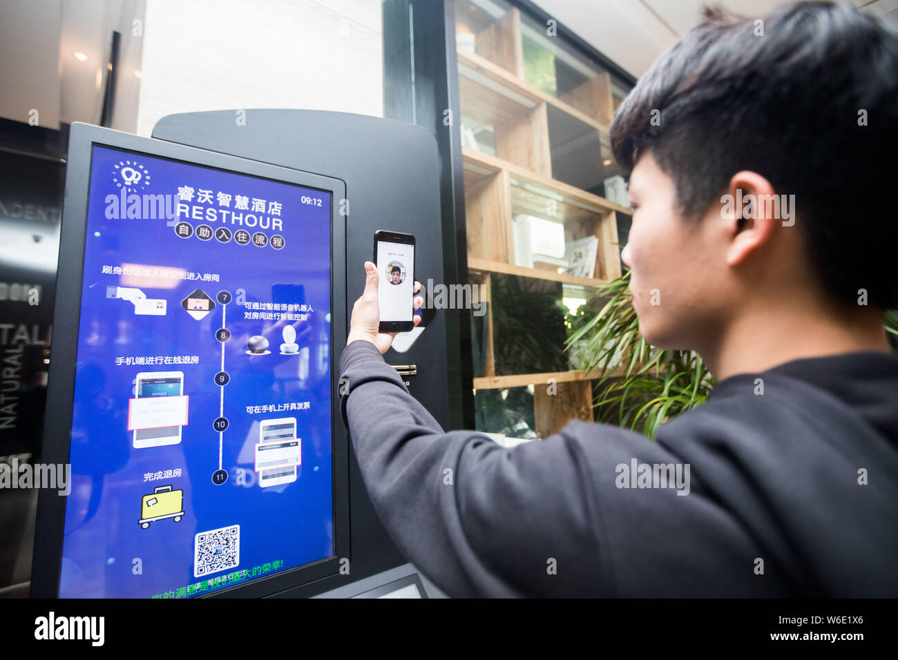 Un uomo cinese senza il suo ID card su di lui utilizza la carta di identità elettronica' nel pagamento mobile app Alipay sul suo smartphone per verificare se stesso dalla faccia ri Foto Stock