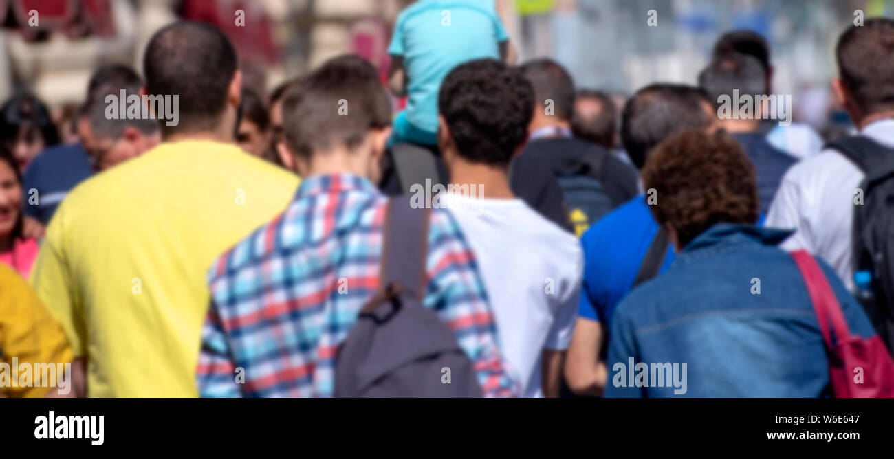 Dimensione lunga immagine con la folla di persone presso la città come sfondo, fuori fuoco foto Foto Stock