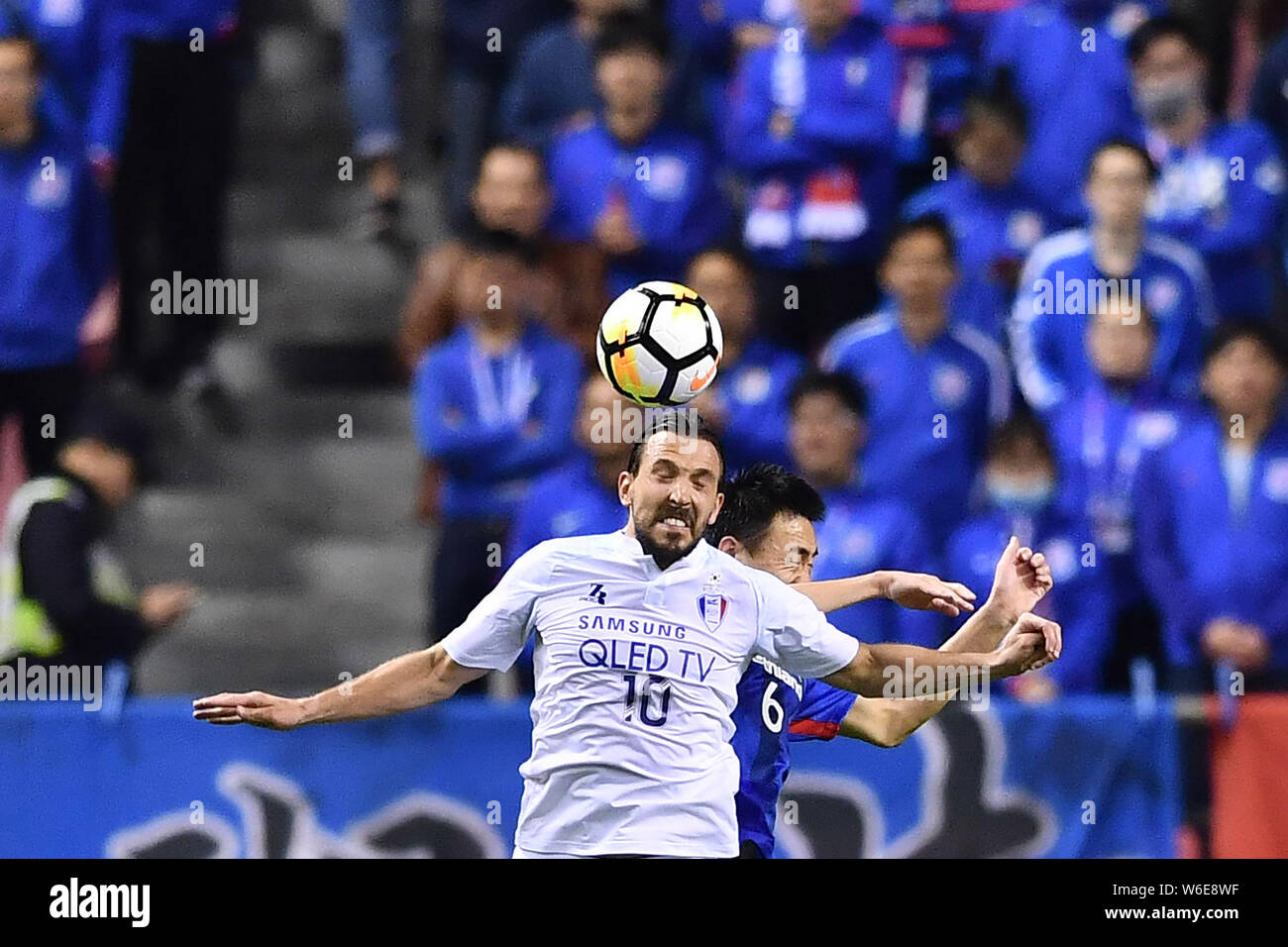 Dejan Damjanovic della Corea del Sud, Suwon Samsung BlueWings FC capi la sfera contro Li Peng di cinese di Shanghai Groenlandia Shenhua FC in un gruppo H matc Foto Stock