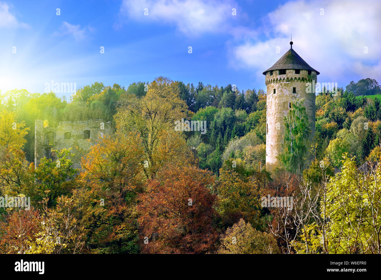 Il vecchio castello medievale torre su una collina nella foresta in Europa su una luminosa giornata di sole. Foto Stock