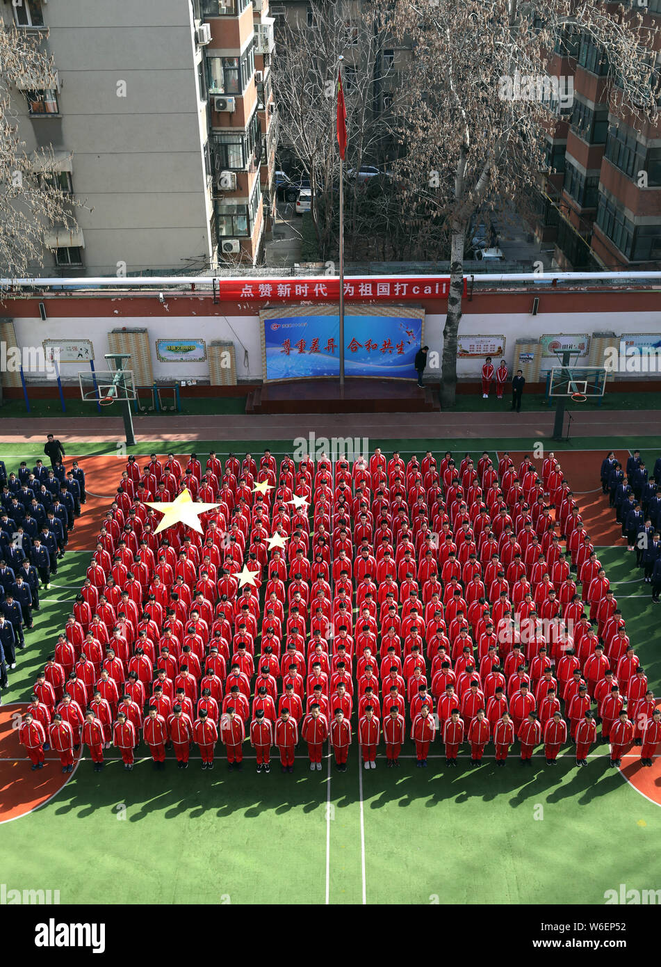 Vista aerea del 384 gli studenti delle scuole medie vestito di rosso formando una formazione nella forma della bandiera nazionale cinese il primo giorno di scuola in J Foto Stock