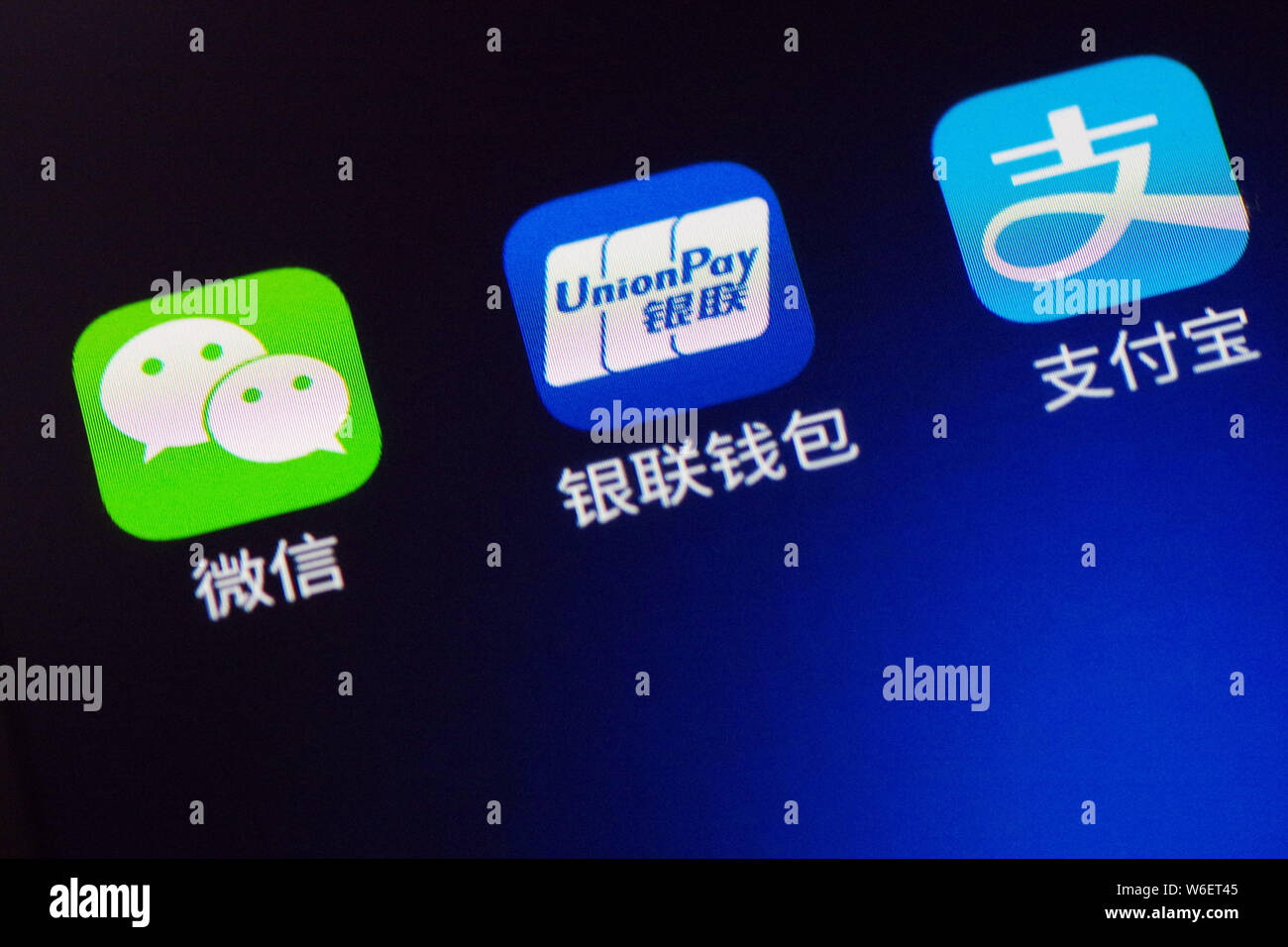 --FILE--un cinese utente del telefono mobile mostra le icone delle applicazioni mobile (da sinistra) messaging app Weixin o WeChat, di Tencent, portafoglio mobile UnionPay Foto Stock