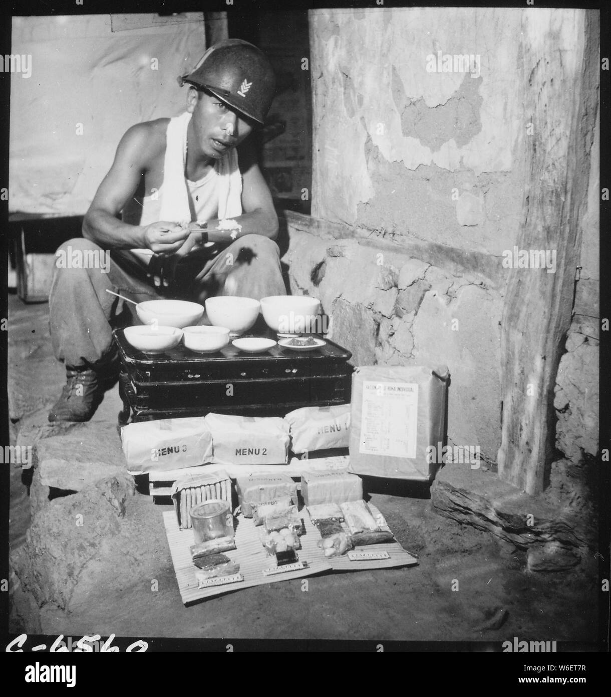 Un soldato della Repubblica di Corea esercito di mangiare il pranzo in una guerra-distrutto casa in Munsan-ni, Corea, come una razione di campo realizzato in Giappone per la Repubblica di Corea esercito è mostrato spacchettato.; Note Generali: Utilizzo di guerra e di conflitto numero 1473 quando si ordina una riproduzione o la richiesta di informazioni su questa immagine. Foto Stock