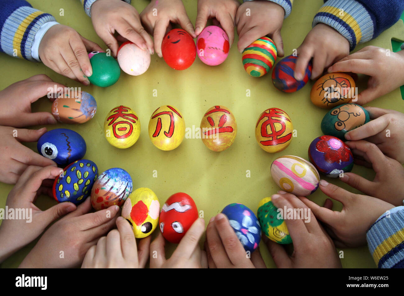 I bambini mostrano le uova dipinte con i caratteri cinesi e i colori per segnare il giorno di 'Chunfen' (equinozio di primavera o equinozio di primavera) in un asilo nido a Han Foto Stock
