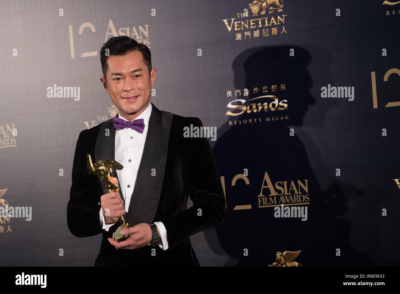 Hong Kong cantante e attore Louis Koo pone con il suo trofeo dopo aver vinto il premio di miglior attore per il suo film "paradosso" durante il dodicesimo Asian Film Award Foto Stock