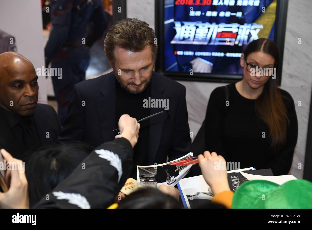 Attore di Hollywood Liam Neeson firma autografi per i fan come egli arriva sul tappeto rosso per la premiere del suo nuovo film " commuter " a Pechino in Cina Foto Stock