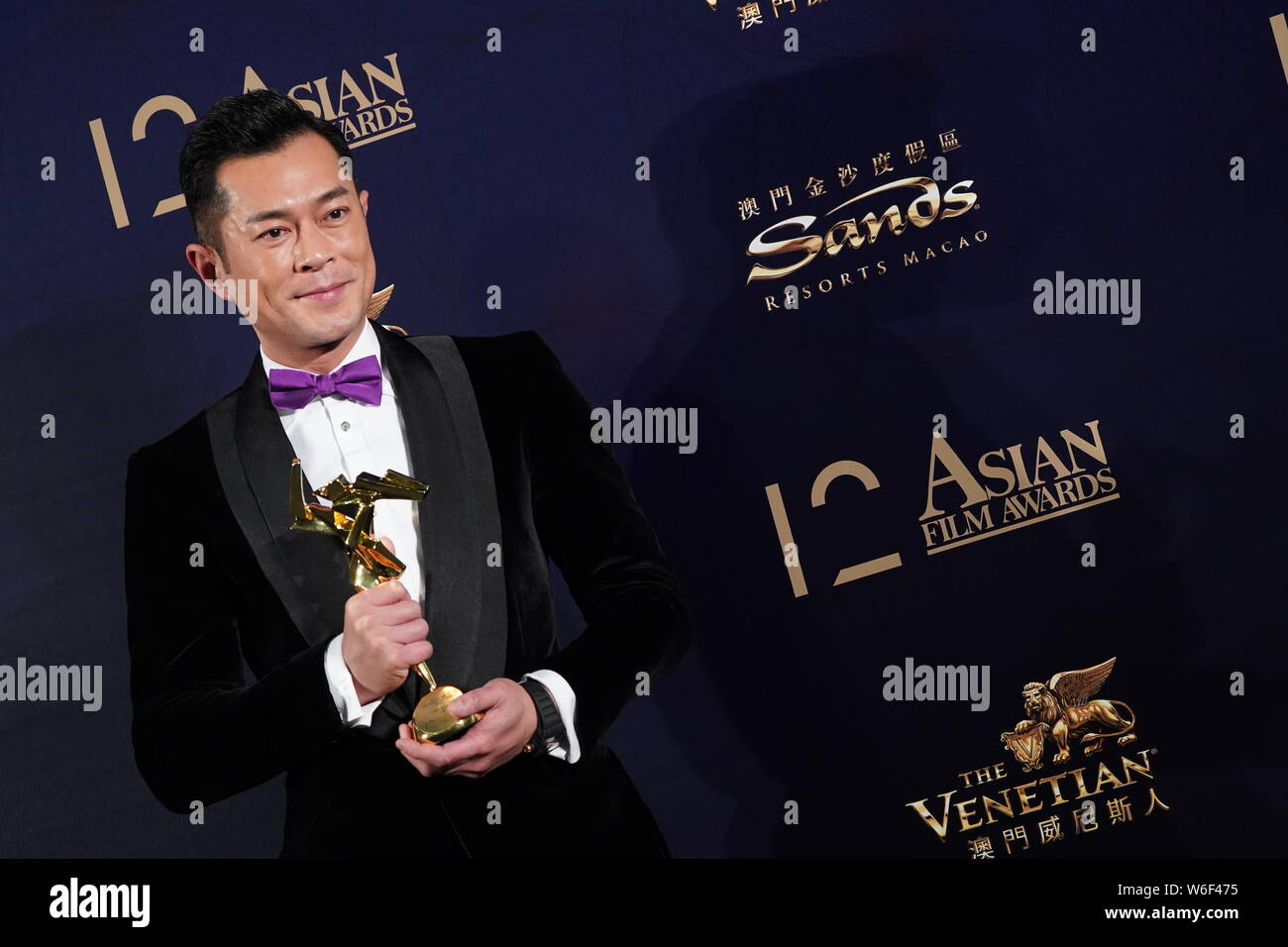 Hong Kong cantante e attore Louis Koo pone con il suo trofeo dopo aver vinto il premio di miglior attore per il suo film "paradosso" durante il dodicesimo Asian Film Award Foto Stock