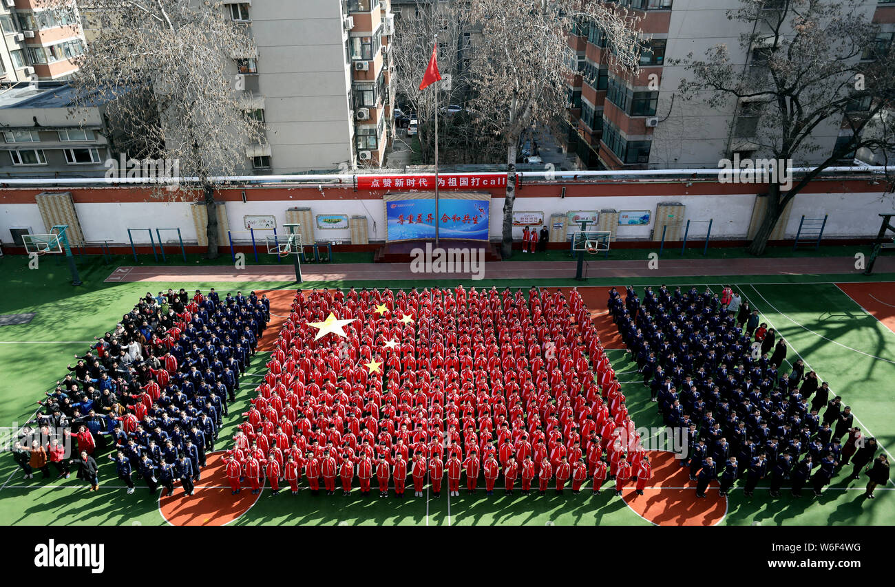 Vista aerea del 384 gli studenti delle scuole medie vestito di rosso formando una formazione nella forma della bandiera nazionale cinese il primo giorno di scuola in J Foto Stock