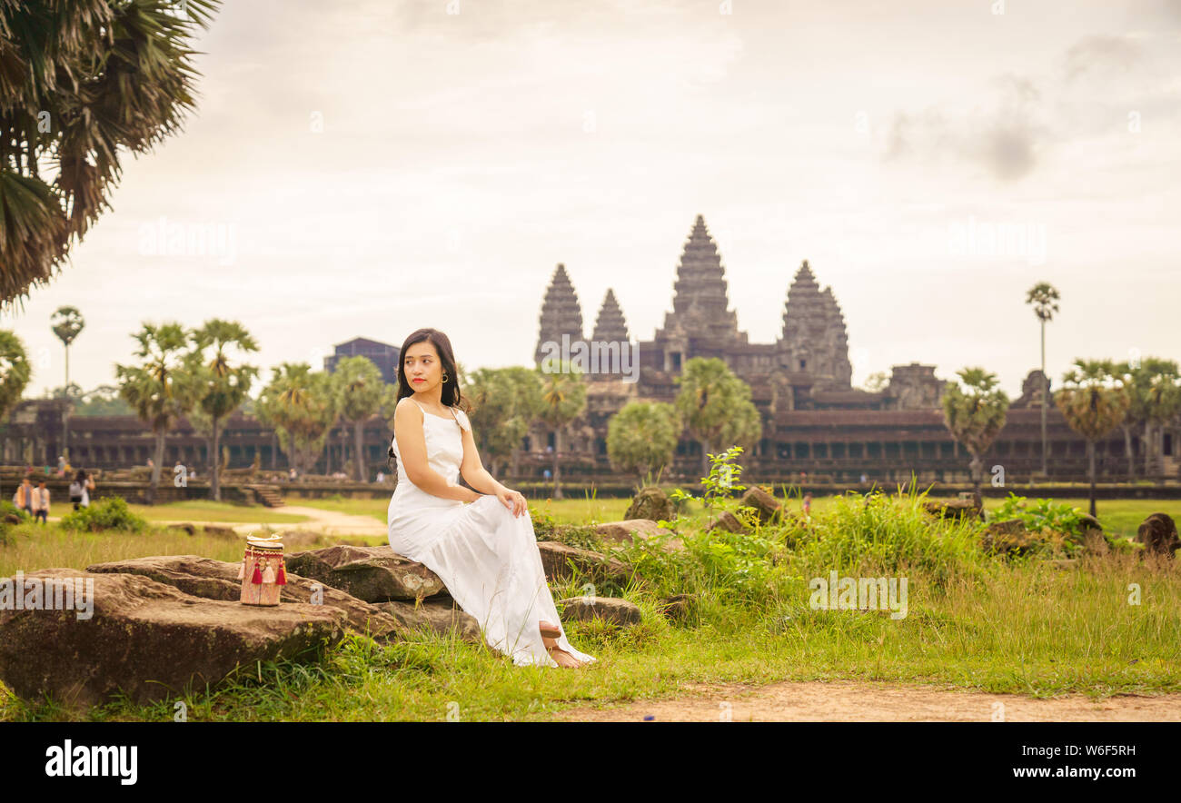 Emancipated asiatica donna solista traveler ad esplorare il tempio di Angkor Wat, Siem Reap, Cambogia in abito bianco Foto Stock