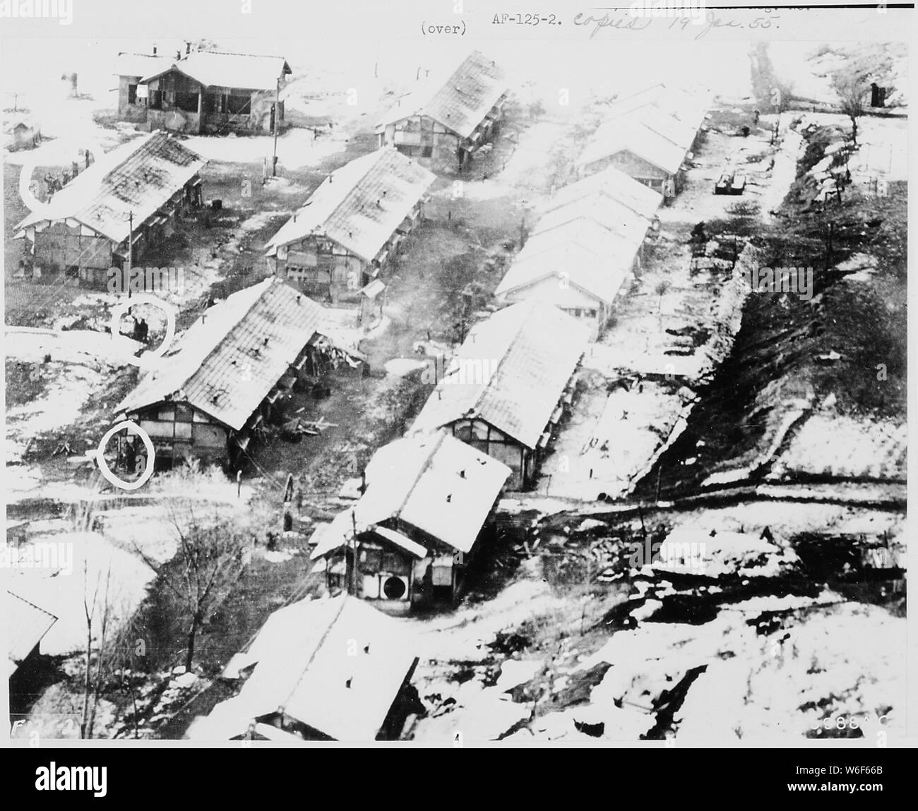 Foto aeree effettuate da basso-battenti disarmato U.S. Air Force jet aerei di ricognizione ha rivelato queste caserme di strutture del tipo vicino Chiktong in Corea del Nord, che si ritiene nemico della casa-held ONU prigionieri di guerra. Questa sezione ingrandita mostra soldati, alcuni sventolando, altri solo guardando il velivolo overhead. La loro vera identità è un mistero. Le strutture non mostrano segni che ufficiali comunisti hanno promesso di utilizzare su tutti i campi di prigionieri di alloggiamento della guerra. Foto Stock