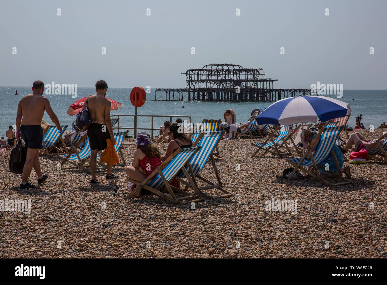 Vacanzieri godere il caldo sul lungomare di Brighton, cittadina balneare nella contea di East Sussex, England, Regno Unito Foto Stock