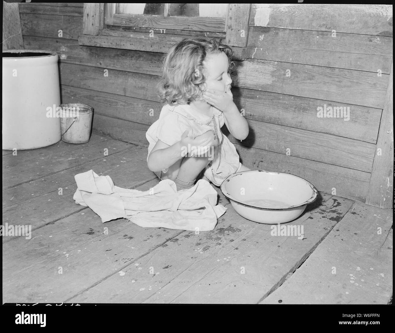 Bobbie Jean Sergent, 4, bagna il suo viso sulla backporch della sua casa. P V & K Coal Company, Trifoglio Gap miniera, Lejunior, Harlan County, Kentucky. Foto Stock