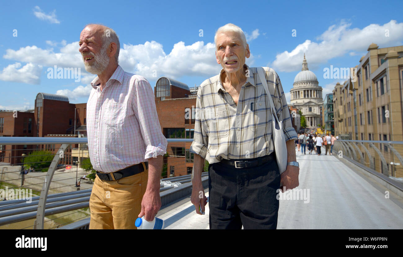 Londra, Inghilterra, Regno Unito. Due uomini che attraversa il Millennium Bridge Foto Stock