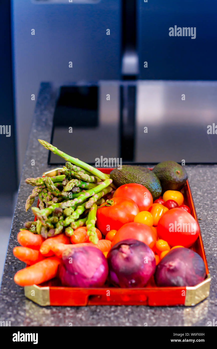 Un vassoio di verdure fresche e frutta in una moderna cucina, con fuoco selettivo Foto Stock