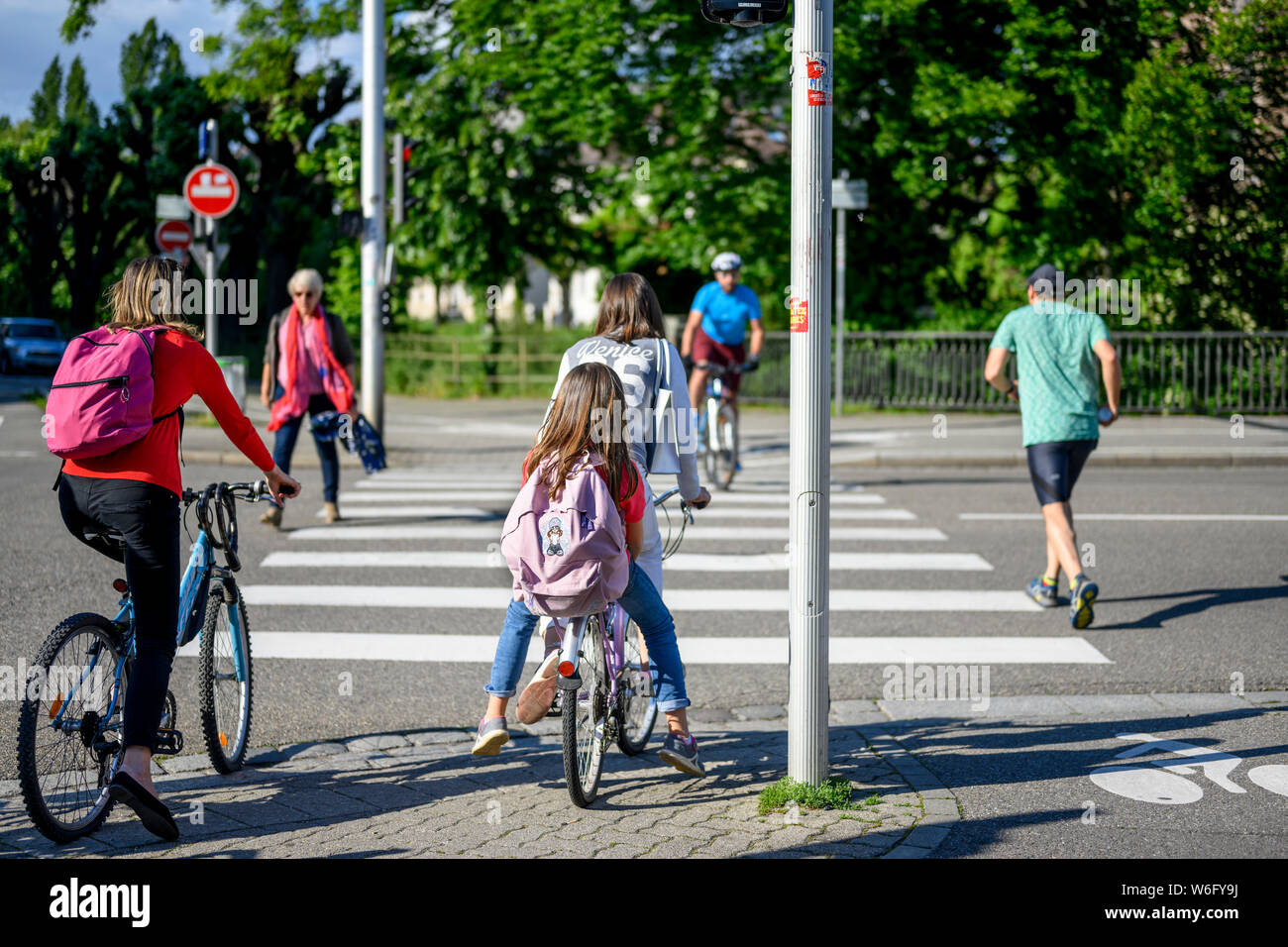 I ciclisti in attesa di cross street a crosswalk, pedoni che attraversano street, Strasburgo, Alsazia, Francia, Europa Foto Stock