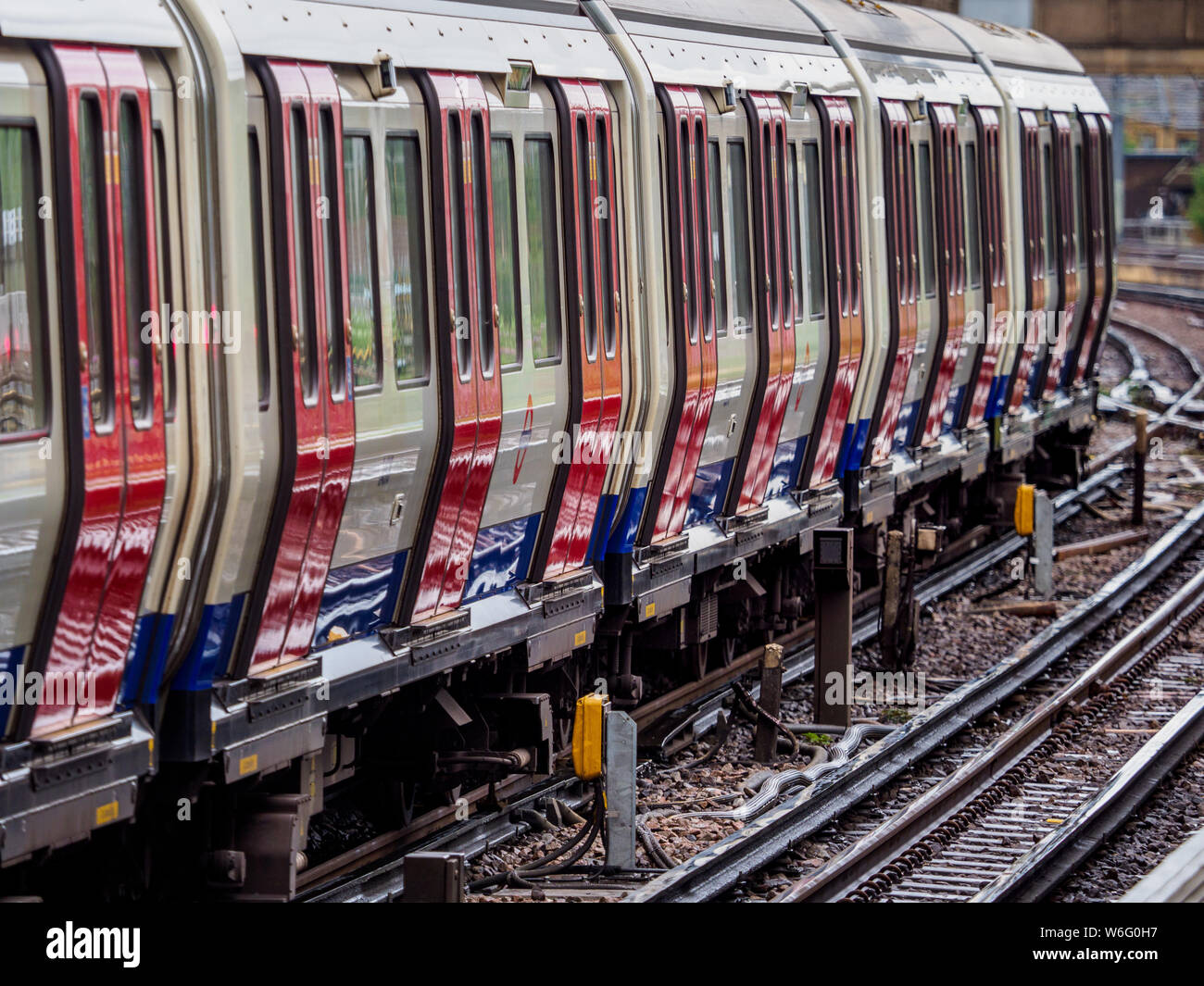 Treno tubo London - London Underground treno della District Line in esecuzione su una sezione di superficie a est del prosciutto dalla stazione di East London Foto Stock