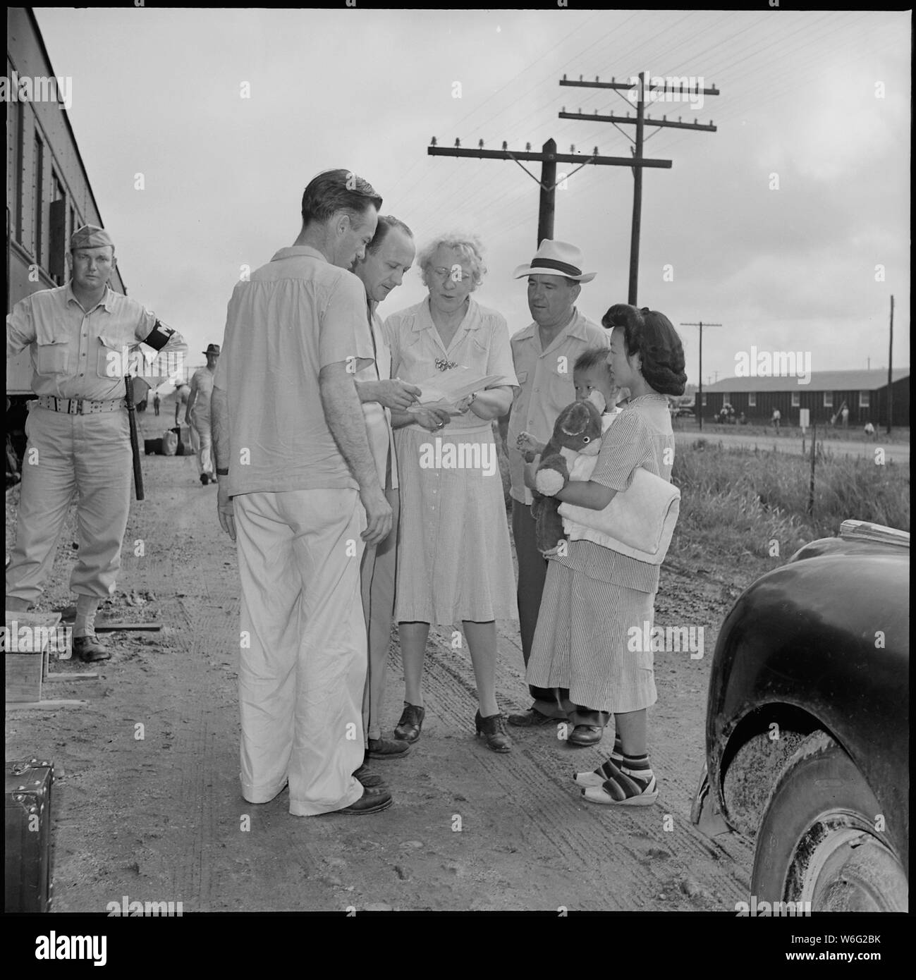 La chiusura del Jerome Relocation Center, Denson, Arkansas. Robert Allison, lasciare Officer (sinistra) un . . .; Portata e contenuto: tutta la didascalia per questa fotografia si legge: Chiusura del Jerome Relocation Center, Denson, Arkansas. Robert Allison, lasciare Officer (sinistra) e Charlie Lynn, rapporti Officer, Miss Enrico di lasciare l'ufficio; e Lewis Rice Farm Superintedent, aiuto in direciting mamme con bambini al di sotto dei diciotto mesi di età che erano consentiti pullman regime. Foto Stock