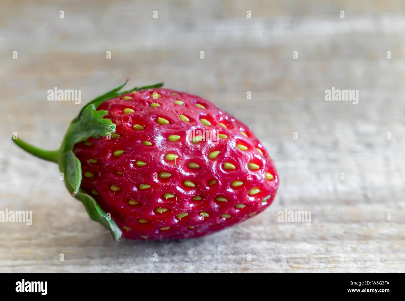 Sul tavolo di legno uno fragole mature. Presentato close-up. Foto Stock